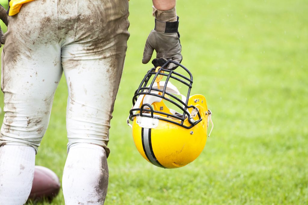 Football Player holding Helmet